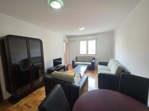 Prostrana dnevna soba sa garniturom za sedenje, velikim ormarom i trpezarijskim stolom. - image 4