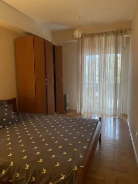 Bright bedroom with a wooden bed, wardrobe, and access to a balcony. - image 19