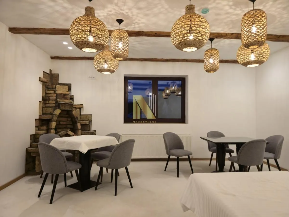 Prostrana trpezarija sa modernim stolicama i ukrasnim lusterima.