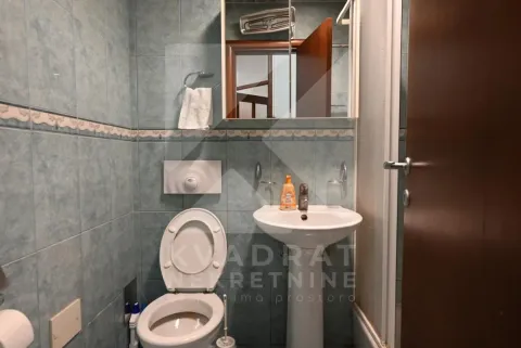 Smaller tiled bathroom with a toilet, washbasin, and mirror cabinet. - image 21