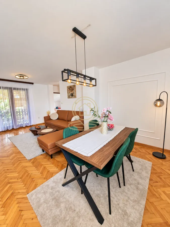 Living room with a dining area, hardwood parquet flooring, and modern furniture.