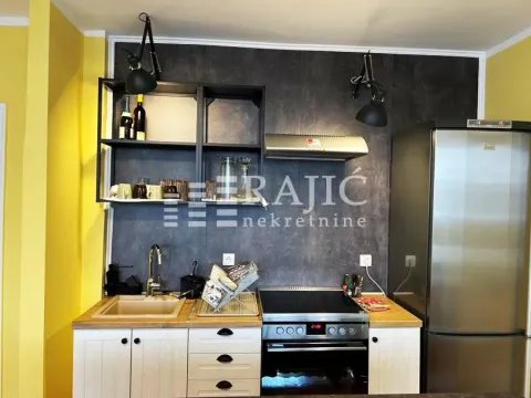 Modern kitchen with dark wall paneling and white units. - image 13