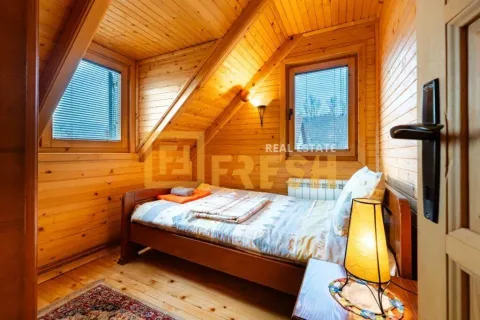 Drvenom obložen potkrovni apartman sa krevetom i prozorima. - image 18