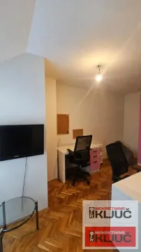 Radna soba sa radnim stolom, stolicom i televizorom na zidu. - image 2