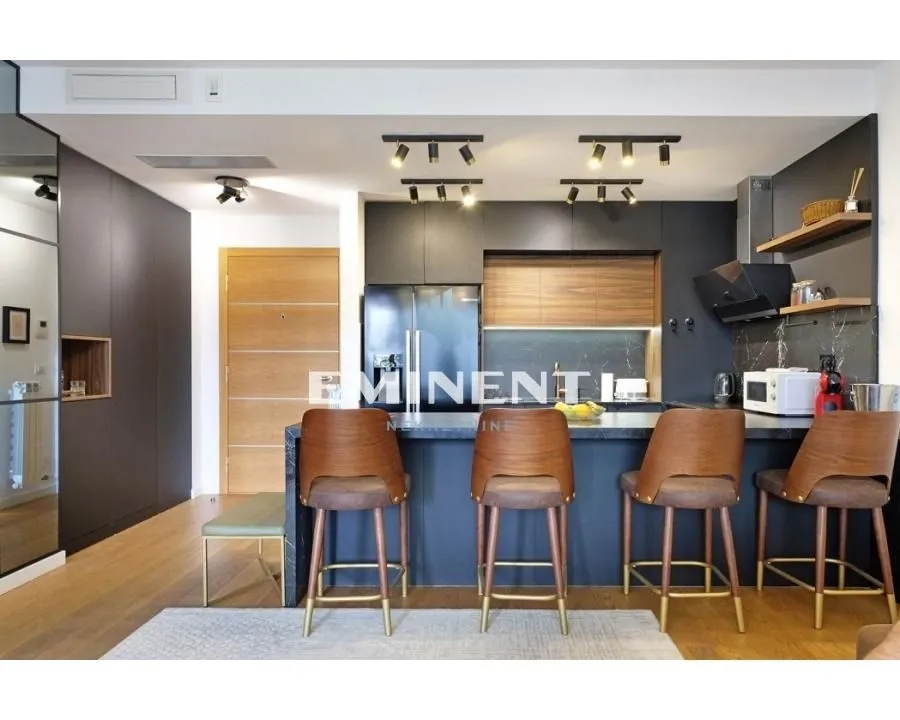 Modern kitchen with a breakfast bar and wooden bar stools.