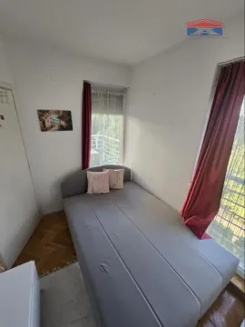 Manja spavaća soba sa krevetom i prozorom koji gleda na prirodu. - image 11