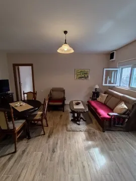 Dnevni boravak sa trpezarijskim stolom, garniturom za sedenje i drvenim podom. - image 3
