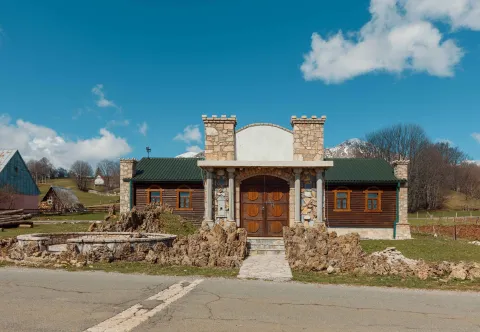 Exterior of an unusual house with stone and wooden details and a yard. - image 10