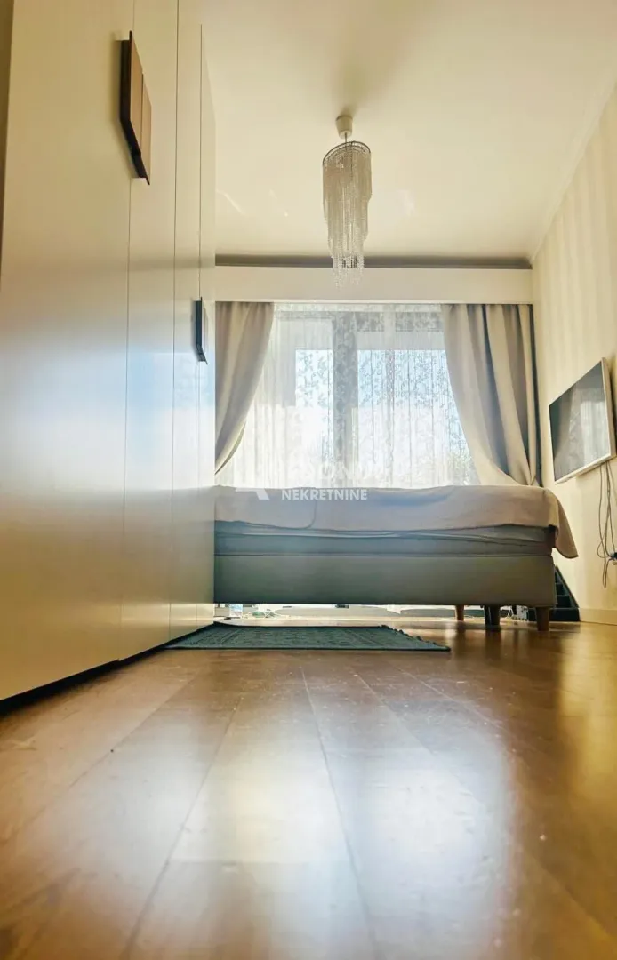 Bedroom with a double bed, wardrobe, and a window with curtains.