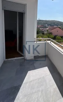 Manji popločani balkon sa pogledom na naselje i vrata koja vode u enterijer. - image 3