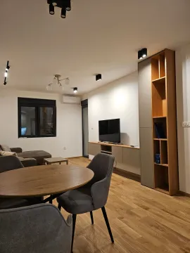 Modern living room with a sofa, dining table, and TV unit. - image 3