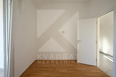 Prazna soba sa parketom i bijelim sobnim vratima. - image 10