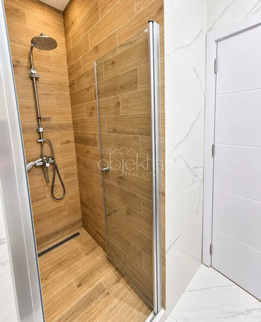 Modern bathroom with a walk-in shower tiled in wood-look tiles.