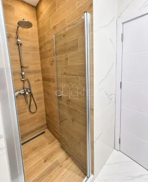Modern bathroom with a walk-in shower tiled in wood-look tiles. - image 8