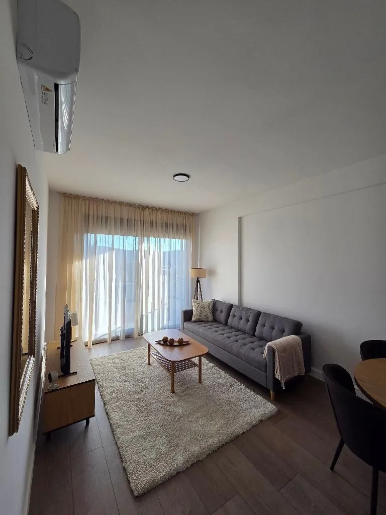 Living room with a sofa, coffee table, and dining table.