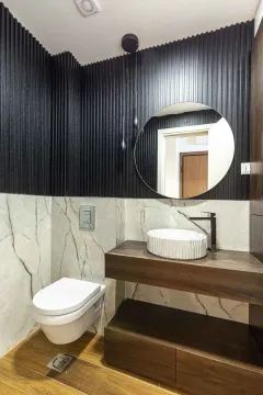 Moderno kupatilo sa drvenim elementima, okruglim ogledalom i konzolnom wc šoljom. - image 2