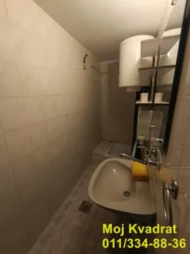 View of the bathroom with a washbasin and a water heater. - image 9