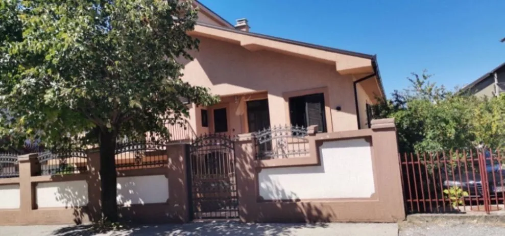 Exterior view of a family house with a fence.