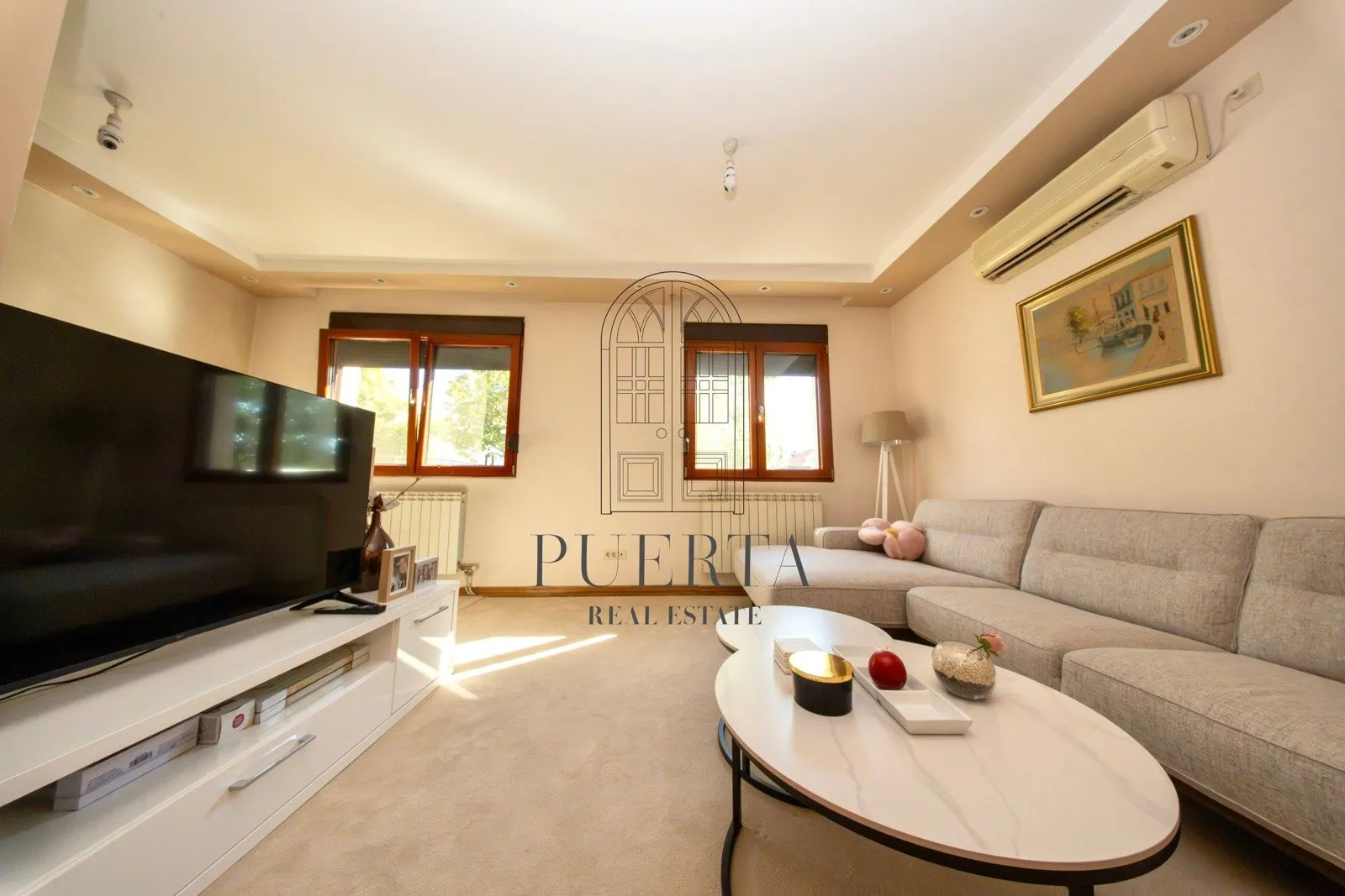 Spacious living room with sofa, TV, and coffee table.