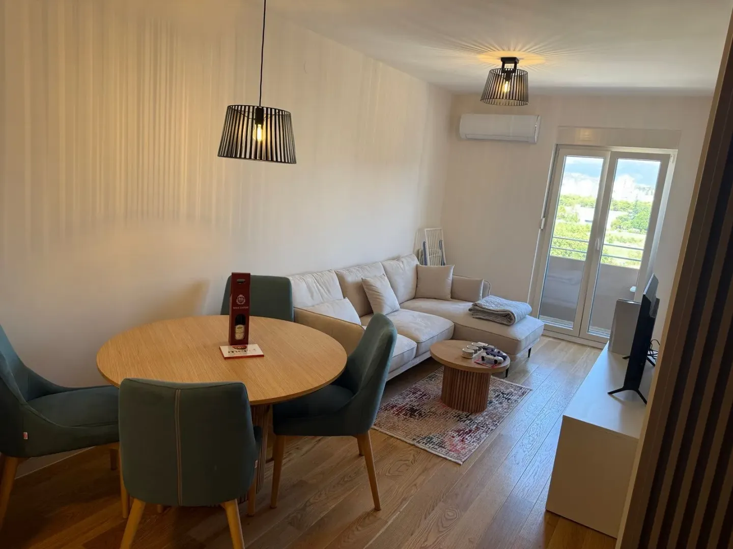 Living room with a sofa, dining table, and access to the terrace.