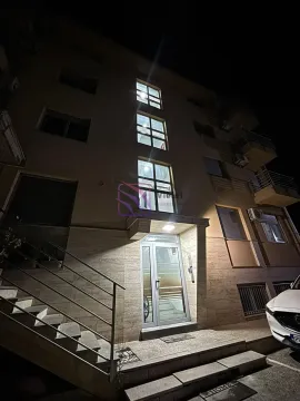 Night view of the illuminated entrance and facade of an apartment building with stairs. - image 11
