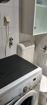 Kupatilo sa veš mašinom, WC šoljom i zidnim elementom. - image 9