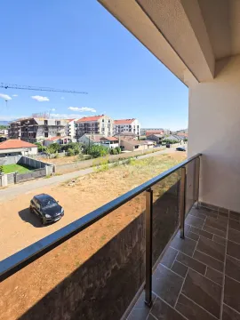 View from the balcony overlooking surrounding buildings and the street. - image 6