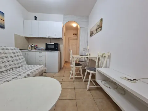 Small kitchen with a dining table and a sofa. - image 2