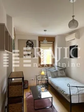 Manja spavaća soba sa krevetom i dekorativnim elementima. - image 8