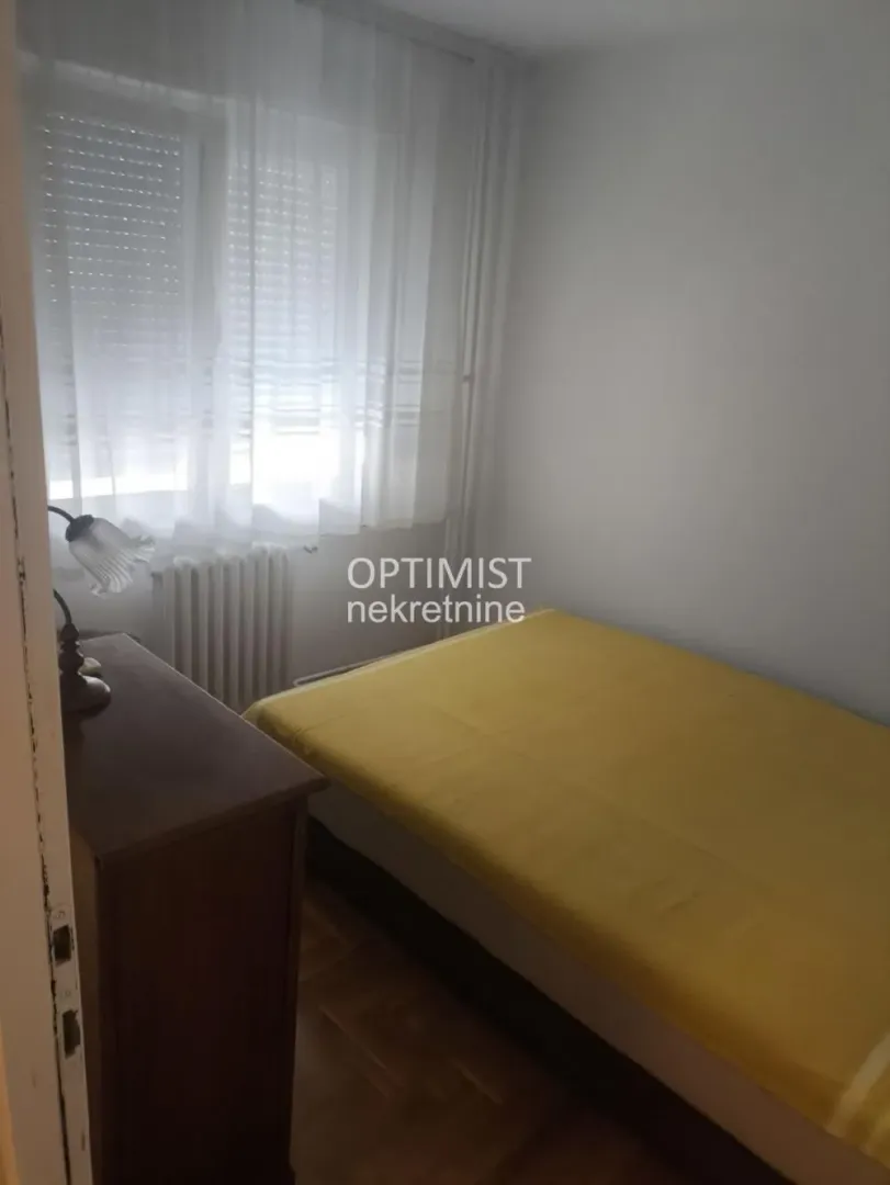 Smaller bedroom with a bed, dresser, and a window.