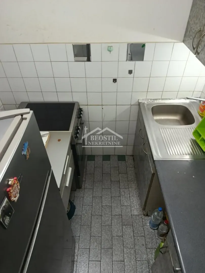 Smaller kitchen with a stove, refrigerator, and sink.