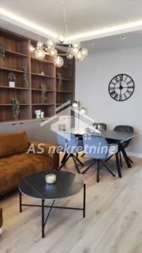 Living room with sofa, dining area, and large wall shelving unit. - image 5