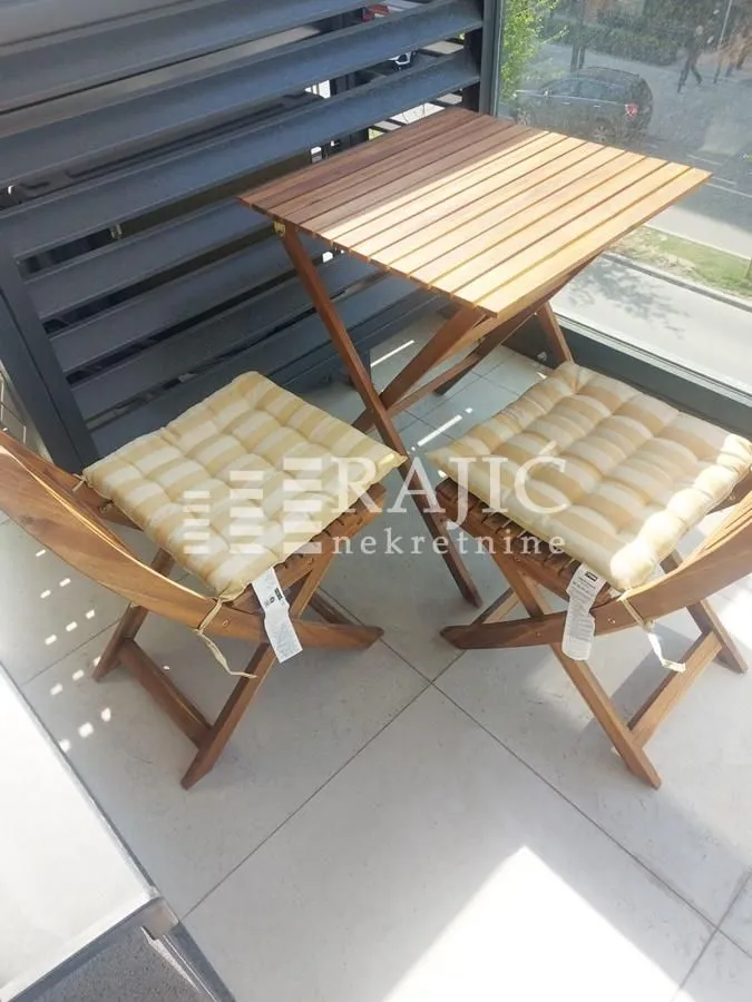 Small wooden furniture set with a table and two chairs on the terrace.