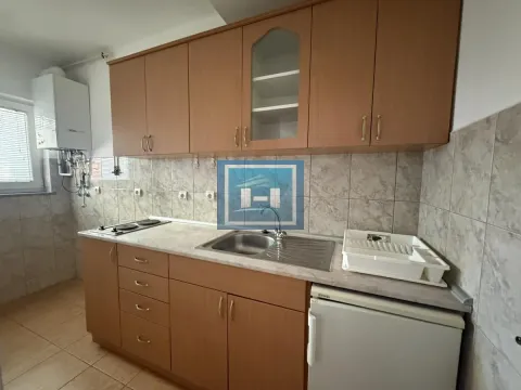 Kuhinja sa drvenim elementima, sudoperom i ugrađenom pločom za kuvanje. - image 3