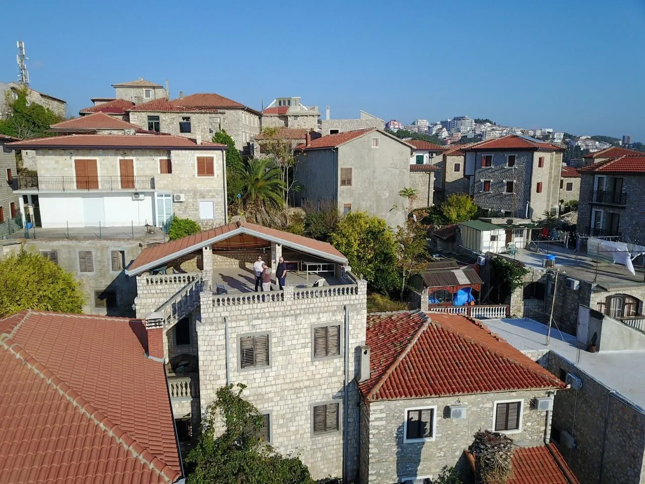 Pogled iz vazduha na kamene kuće sa krovovima od crvenog crijeva i terasom.
