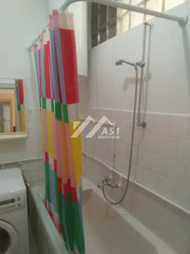 Bathroom with a bathtub, shower set, and a colorful curtain. - image 6