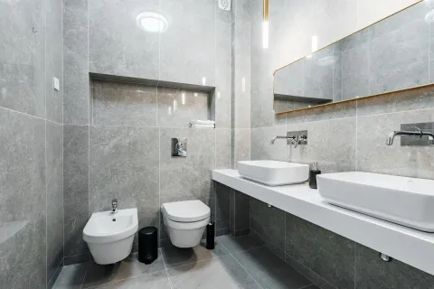 Moderne opremljeno kupatilo sa dva umivaonika i sivim pločicama. - image 9