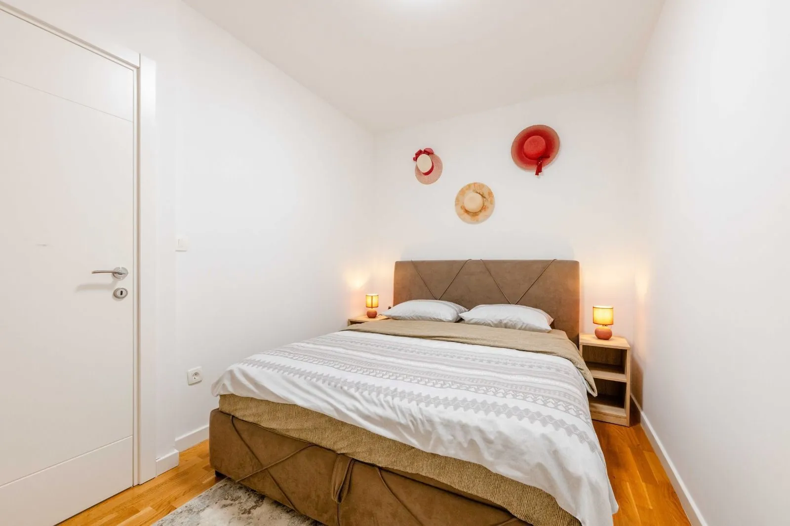 Bedroom with a double bed, bedside tables, and wall decoration.