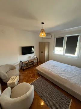 Furnished bedroom with a double bed, armchairs and a TV. - image 2