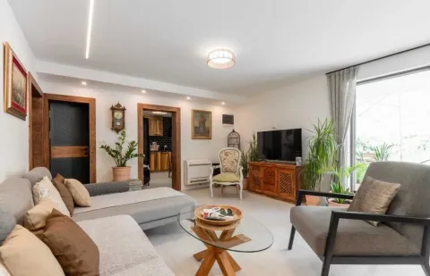 Spacious living room with a sofa set, television, and view of the terrace. - image 5