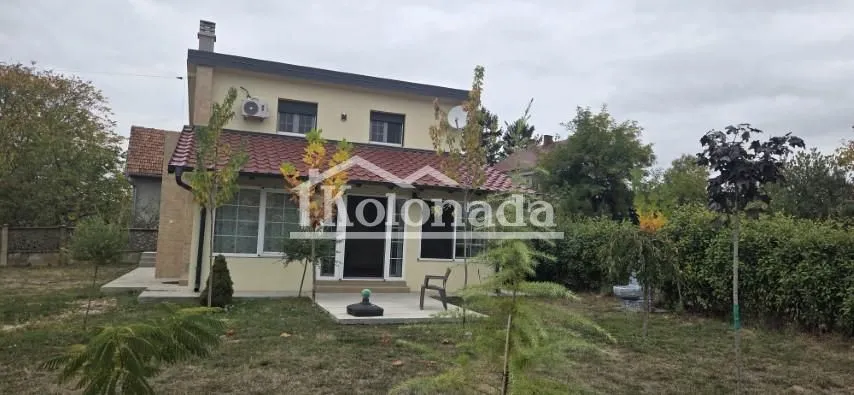 Pogled na dvorište i spoljašnjost kuće sa uređenom okućnicom.