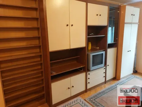 Dnevna soba sa velikim drvenim ormarom i televizorom. - image 2
