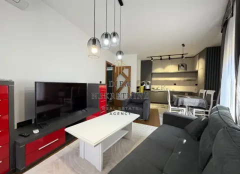 Moderan dnevni boravak sa garniturom, televizorom i trpezarijom u pozadini. - image 3