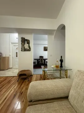 View of a bright living room with a sofa and a passageway towards the dining area. - image 3