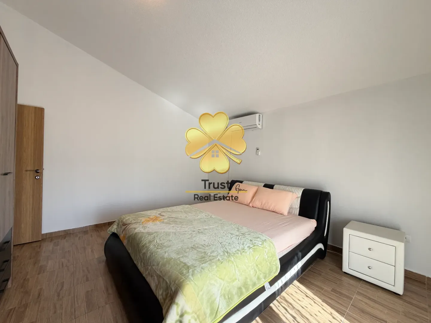 Bedroom with a double bed, white walls, and a wardrobe.