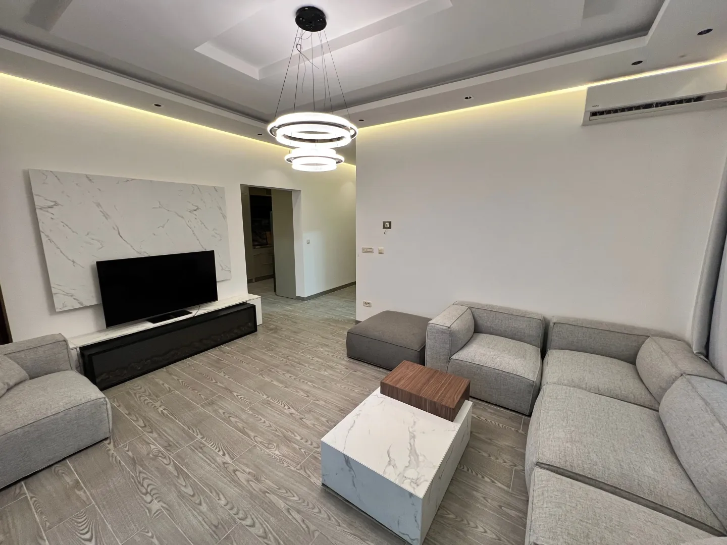 Modern and bright living room with a sofa and television.