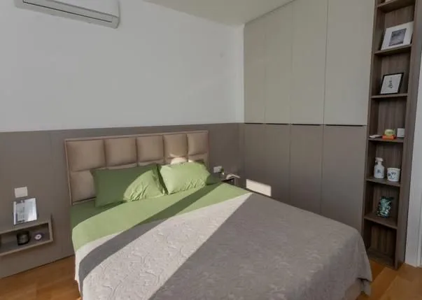 Furnished bedroom with a double bed, built-in wardrobe, and bookshelf.