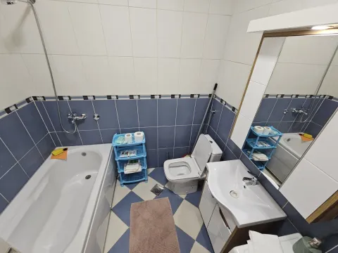 Jednostavno kupatilo sa kadom, lavaboom i plavo-bijelim pločicama. - image 15