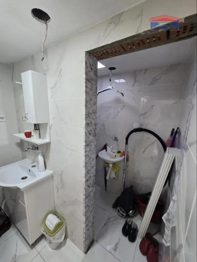 Small bathroom with a washbasin and ceramic tiles.