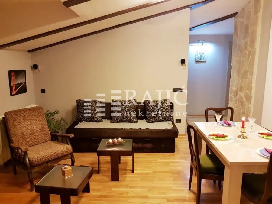 Living room with dining area and wooden flooring.